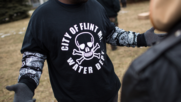 A shirt worn by a man during a rally at Flint City Hall in Flint Mich on Jan 24 2016 displays a poisonous logo alongside the text quotCity of Flint MI Water Deptquot The event was organized by Genesee County Volunteer Militia to protest government corruption the group sees in relation to the Flint water crisis which resulted in a federal state of emergency Photo by Brett CarlsenGetty Images