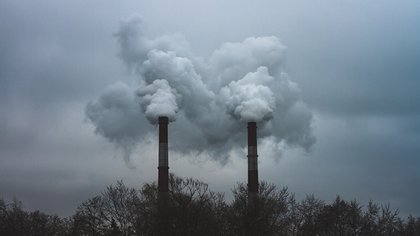 Steam and smoke forms from a boiler at sunset