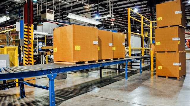 Large boxes sitting on a conveyor rack in a warehouse