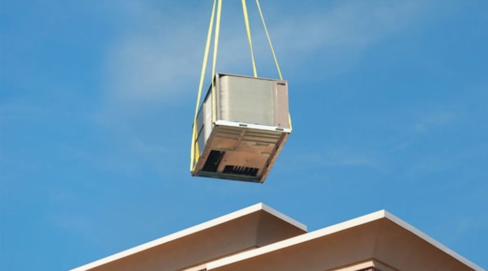 A replacement rooftop unit is lowered into place.