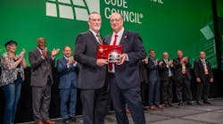 Gregg Wheeler (left) accepting the ceremonial gavel from Code Council&rsquo;s immediate past President Bill Bryant (right) during the Code Council Annual Banquet.