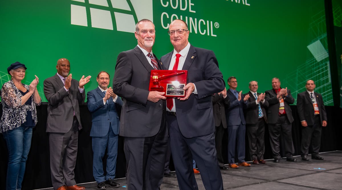 Gregg Wheeler (left) accepting the ceremonial gavel from Code Council&rsquo;s immediate past President Bill Bryant (right) during the Code Council Annual Banquet.