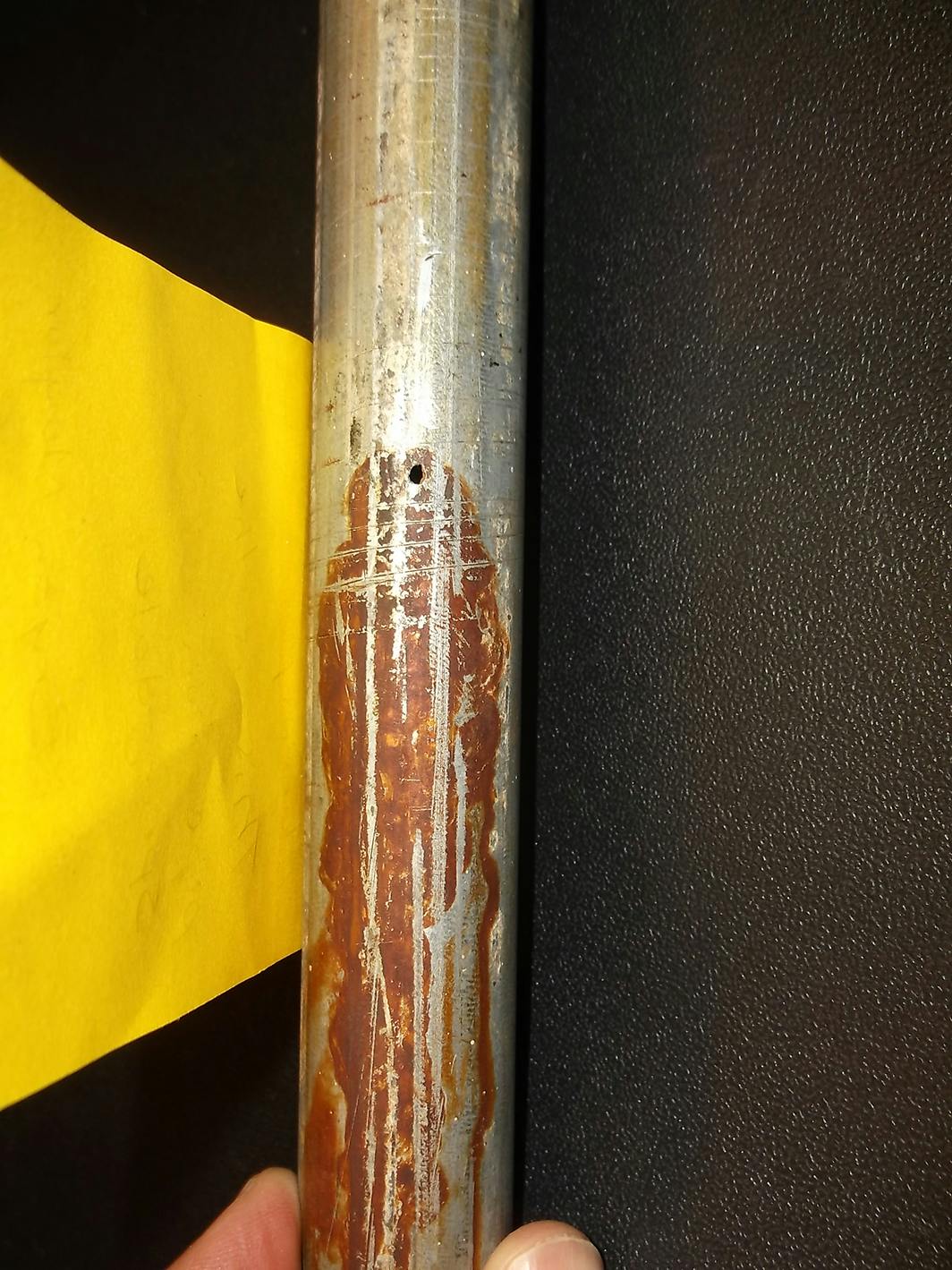 Figure (4): A view of failed Schedule 5 galvanized steel HVAC piping. The rust stain is from leaked water. This piping was part of a school HVAC water source heat pump system.