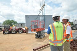 Design and construction team members oversee the installation of a rooftop air-handling unit. Design and construction team members oversee the installation of a rooftop air-handling unit.
